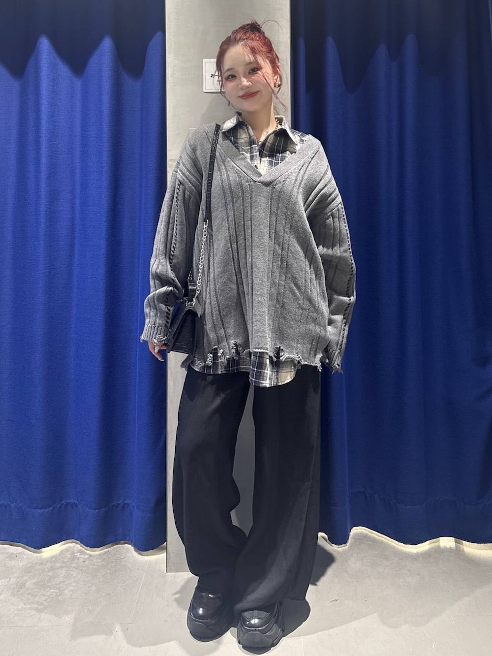 ブラック系のスニーカー、ブラック系のハンドバッグ、ブラック系のスラックスを着用したレディースの秋コーディネートの3枚目の写真