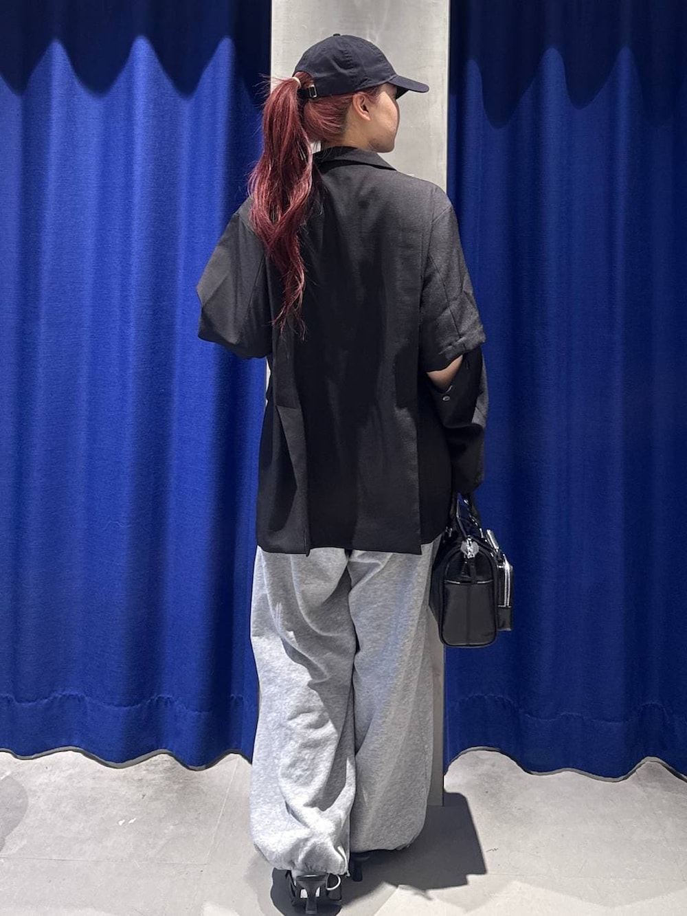 グレー系のスウェットパンツ、ブラック系のショルダーバッグ、ブラック系のサンダルを着用したレディースの春コーディネートの4枚目の写真