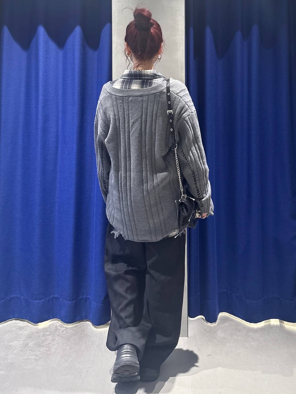 ブラック系のスニーカー、ブラック系のハンドバッグ、ブラック系のスラックスを着用したレディースの秋コーディネートの4枚目の写真