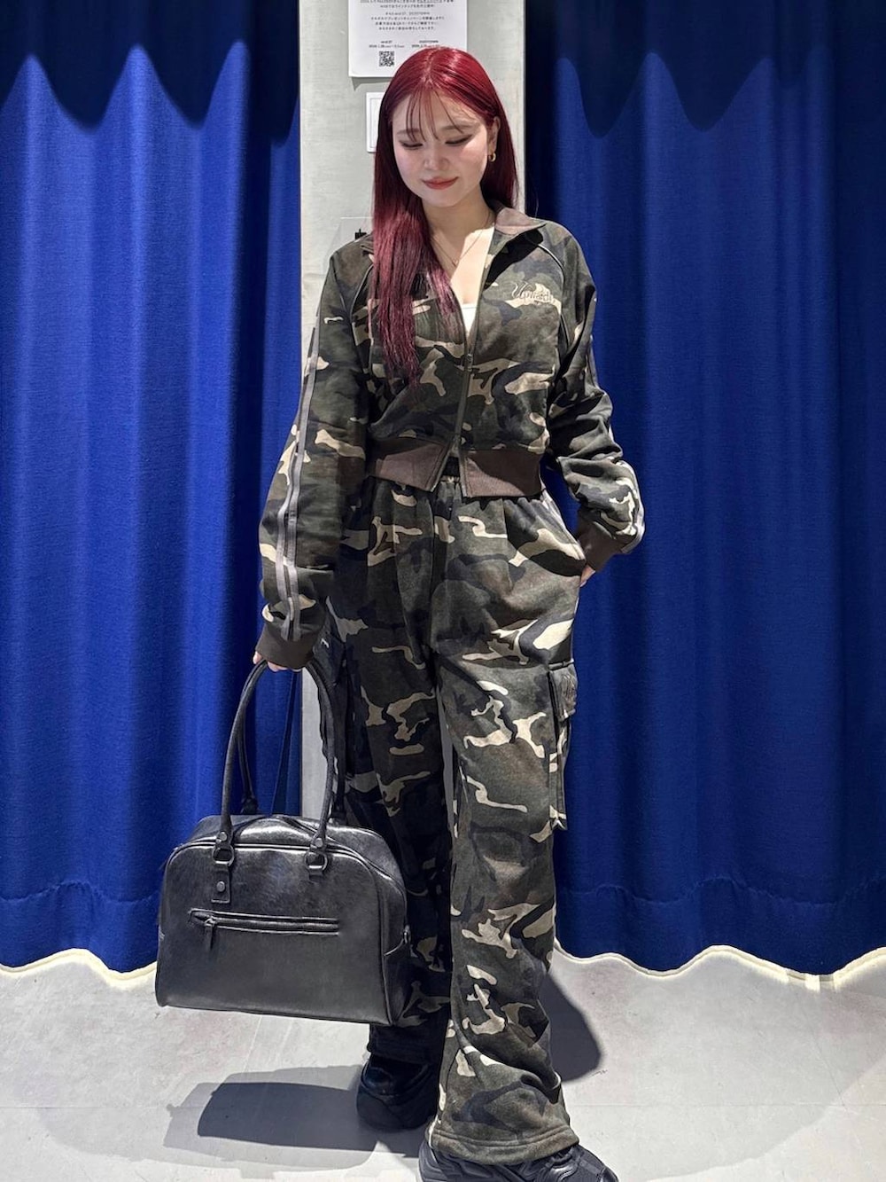 ブラック系のスニーカー、ブラック系のボストンバッグ、ホワイト系のキャミソールを着用したレディースの冬コーディネートの2枚目の写真