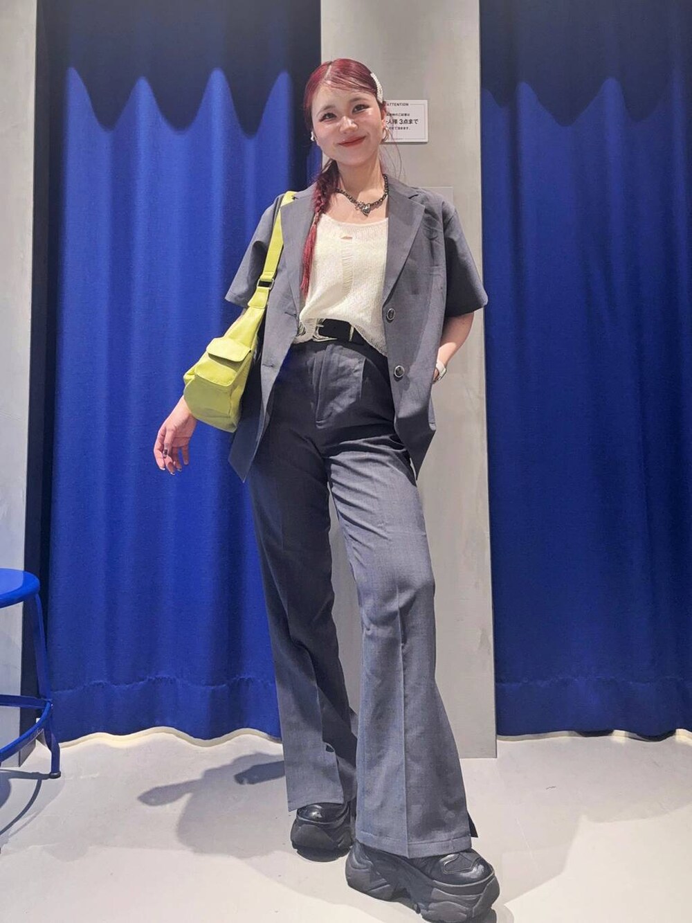 ブラック系のスニーカー、グリーン系のショルダーバッグ、ホワイト系のベストを着用したレディースの夏コーディネートの2枚目の写真