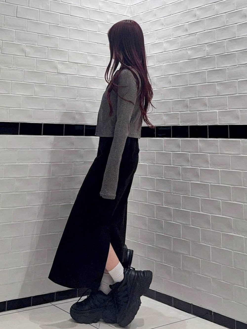 ブラック系のスニーカー、ブラック系のショルダーバッグ、ブルー系のカーディガン/ボレロを着用したレディースの春コーディネートの2枚目の写真