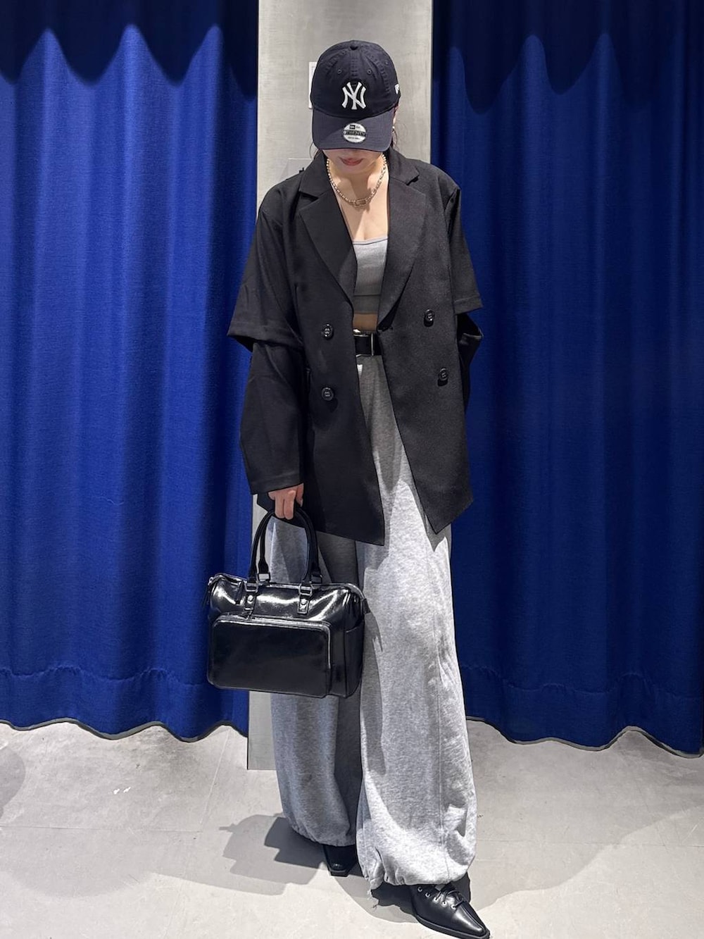 グレー系のスウェットパンツ、ブラック系のショルダーバッグ、ブラック系のサンダルを着用したレディースの春コーディネートの2枚目の写真