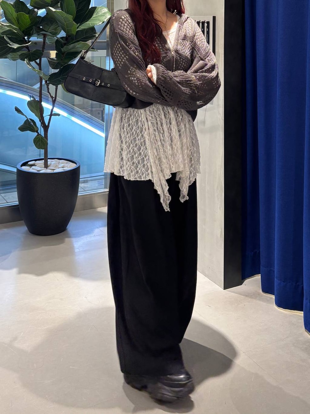 ブラック系のスニーカー、ブラック系のハンドバッグ、ホワイト系のチュニックを着用したレディースの春コーディネートの2枚目の写真