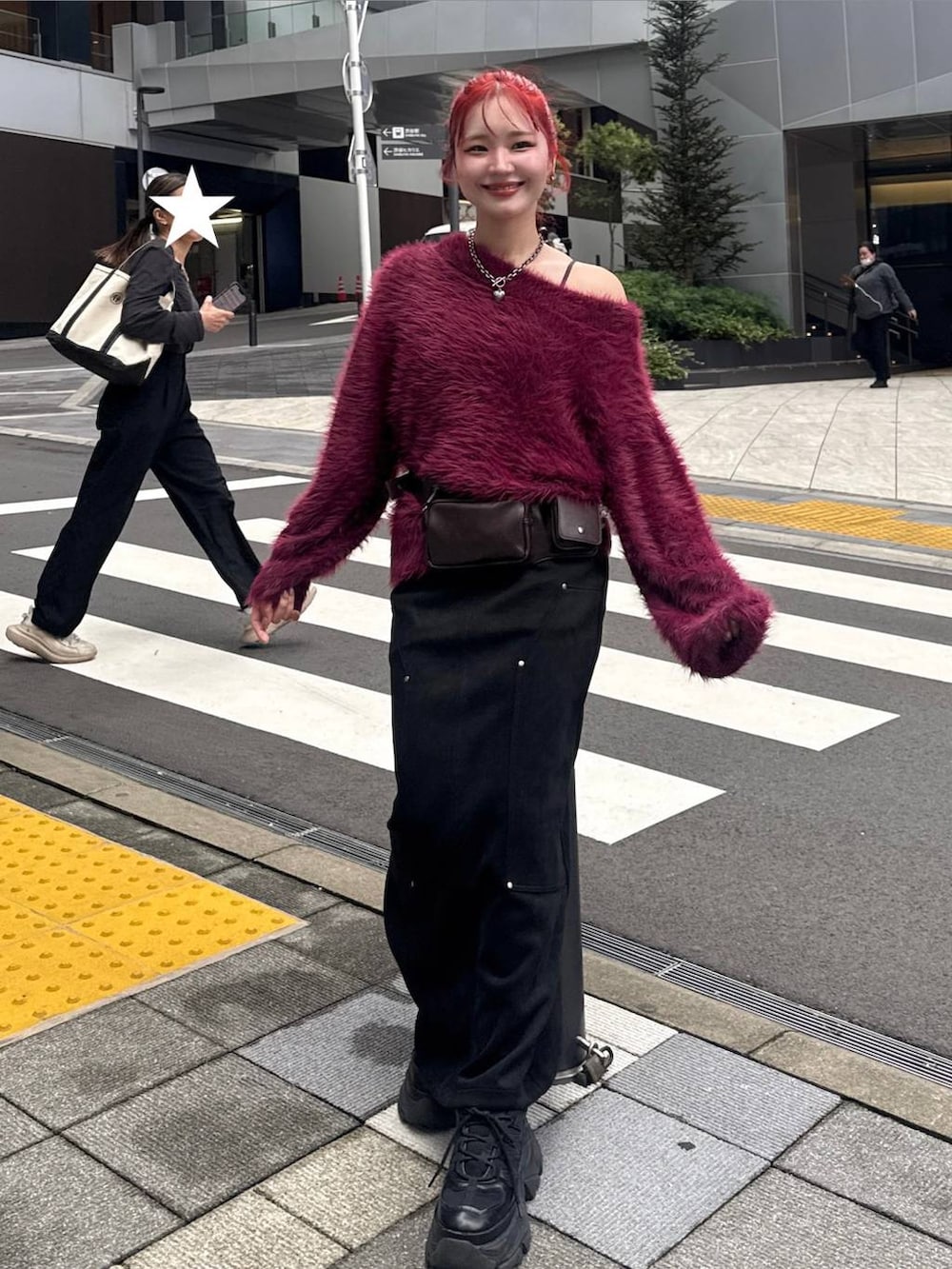 ブラック系のスカート、ブラック系のスニーカー、レッド系のニット/セーターを着用したレディースの秋コーディネートの3枚目の写真