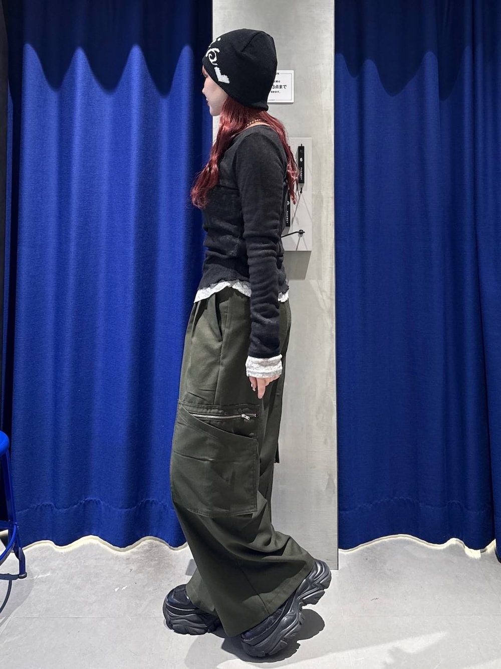 ブラック系のスニーカー、グリーン系のスラックス、ブラック系のハンドバッグを着用したレディースの春コーディネートの3枚目の写真