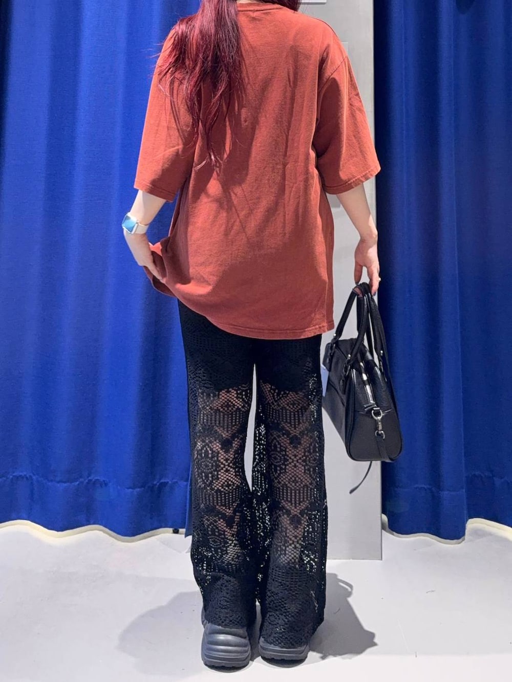 ブラック系のスニーカー、レッド系のTシャツ/カットソー、ブラック系のショルダーバッグを着用したレディースの夏コーディネートの4枚目の写真