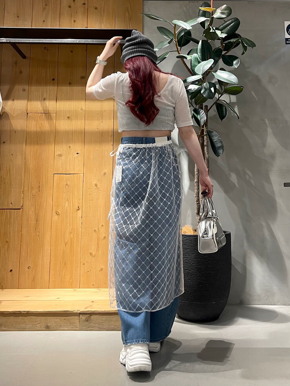 ブルー系のデニムパンツ、シルバー系のショルダーバッグ、ホワイト系のスニーカーを着用したレディースの夏コーディネートの5枚目の写真