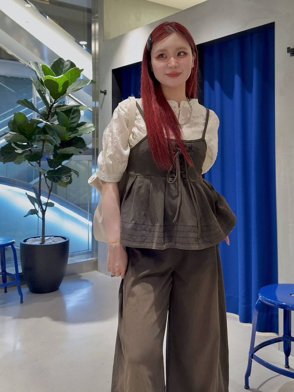 ブラウン系のデニムパンツ、ブラウン系のその他トップス、ブラック系のサンダルを着用したレディースの夏コーディネートの3枚目の写真