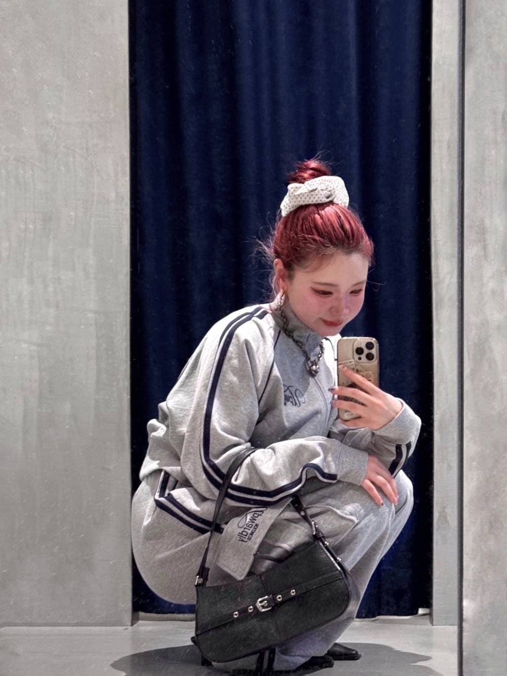 ブラック系のハンドバッグ、ブラック系のサンダル、グレー系のスウェットパンツを着用したレディースの春コーディネートの3枚目の写真