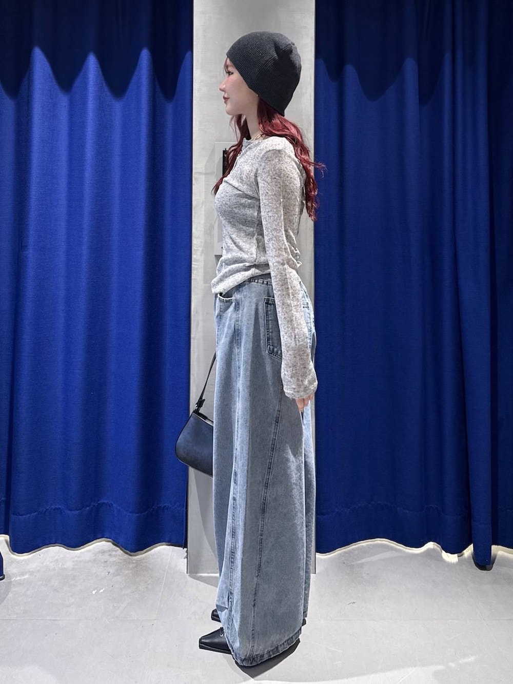 ブラック系のハンドバッグ、ブラック系のサンダル、ブルー系のデニムパンツを着用したレディースの春コーディネートの3枚目の写真