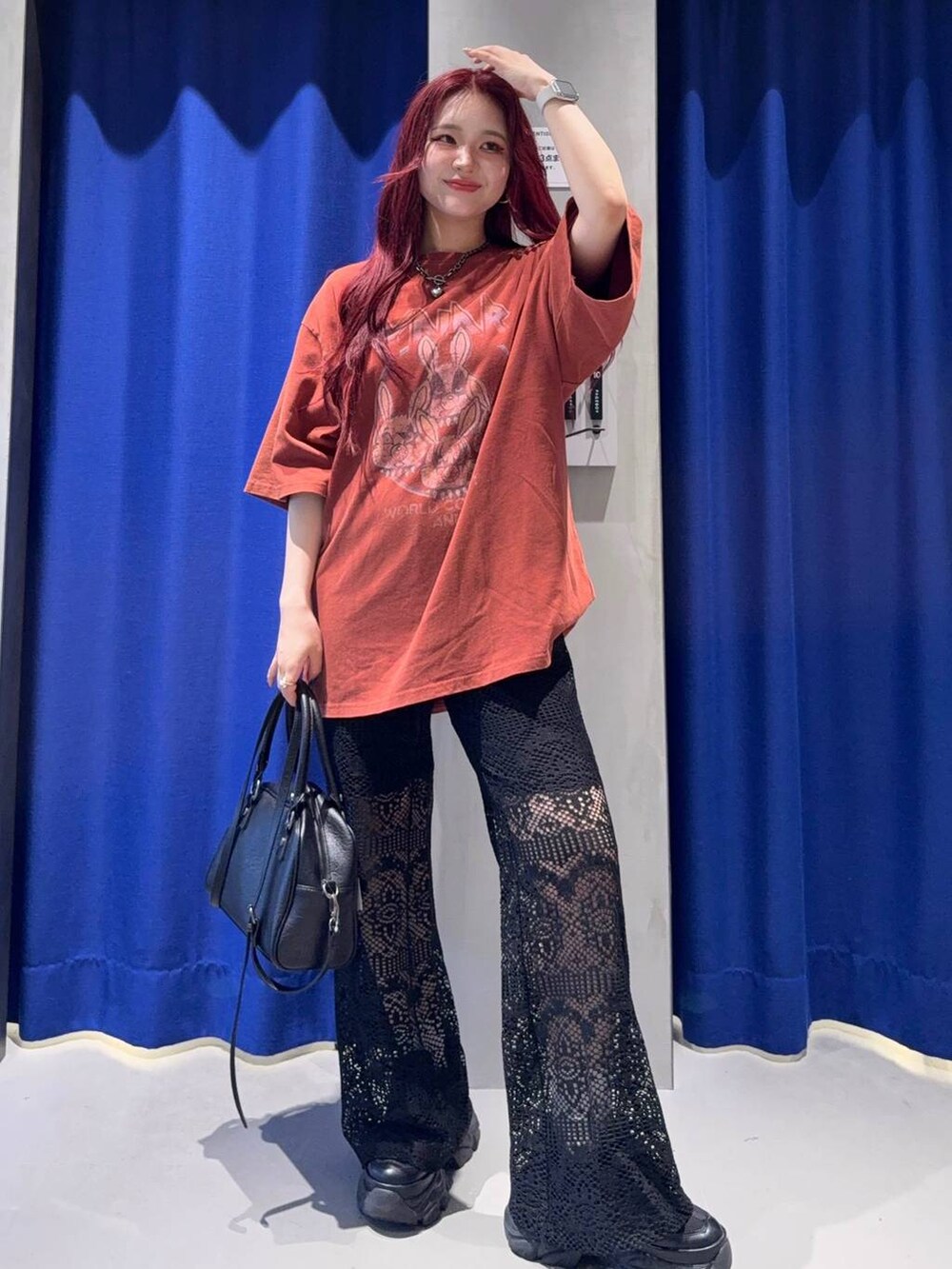 ブラック系のスニーカー、レッド系のTシャツ/カットソー、ブラック系のショルダーバッグを着用したレディースの夏コーディネートの2枚目の写真