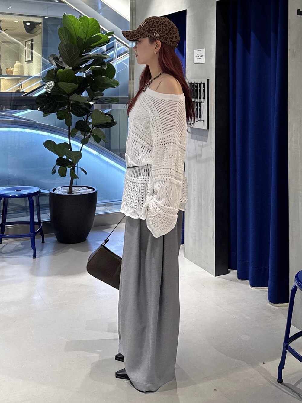 ブラウン系のハンドバッグ、ブラック系のサンダル、ホワイト系のニット/セーターを着用したレディースの春コーディネートの4枚目の写真