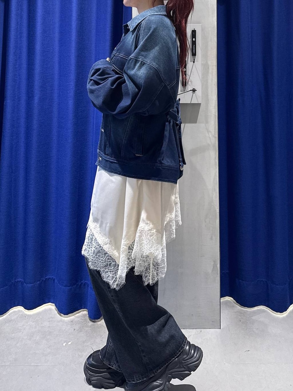 ブラック系のスニーカー、ブルー系のデニムパンツ、ホワイト系のボストンバッグを着用したレディースの冬コーディネートの2枚目の写真