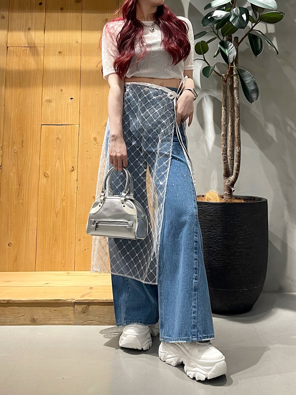 ブルー系のデニムパンツ、シルバー系のショルダーバッグ、ホワイト系のスニーカーを着用したレディースの夏コーディネートの2枚目の写真