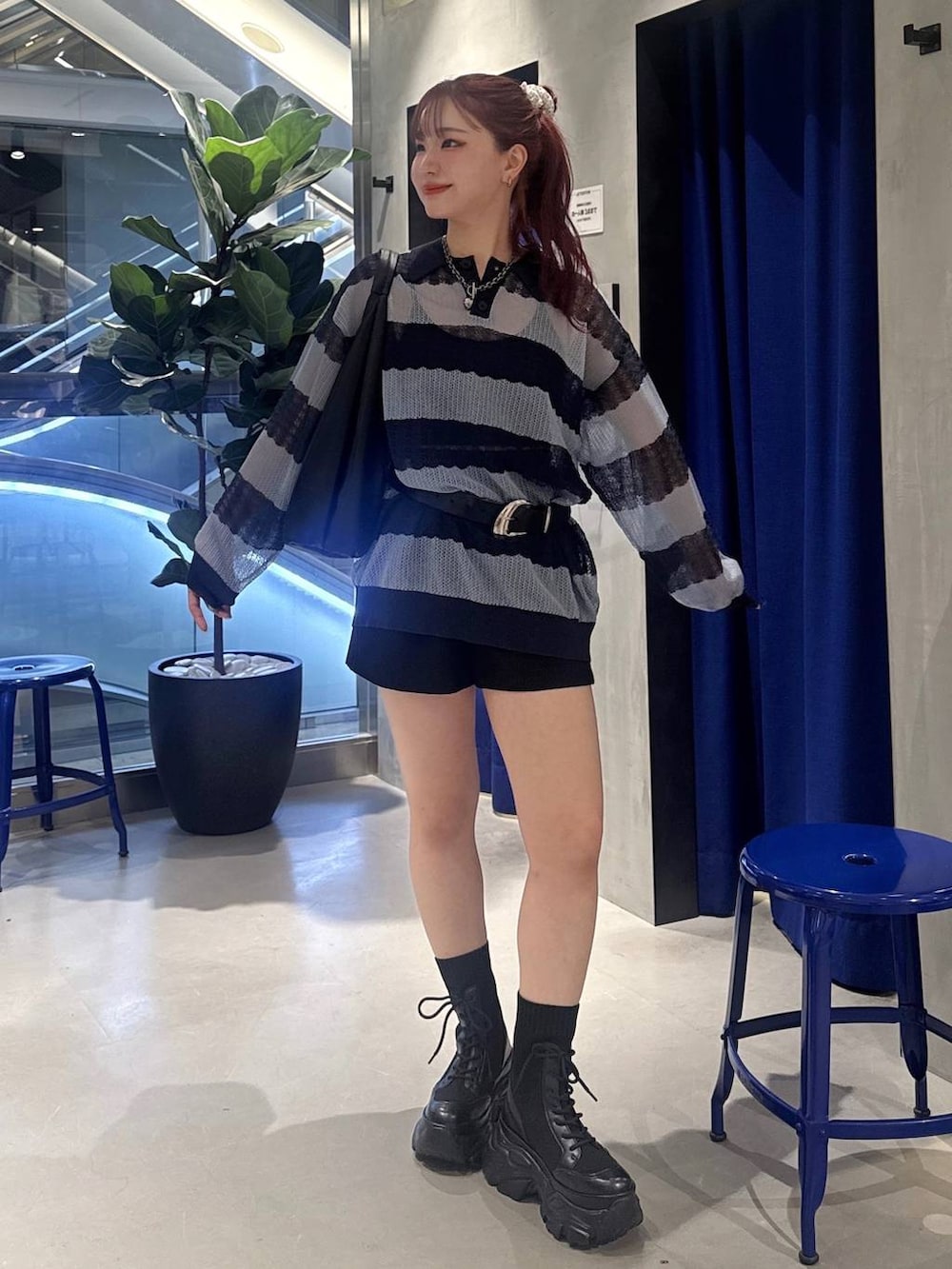 ブラック系のブーツ、ブラック系のトートバッグ、ブラック系のスラックスを着用したレディースの春コーディネートの2枚目の写真