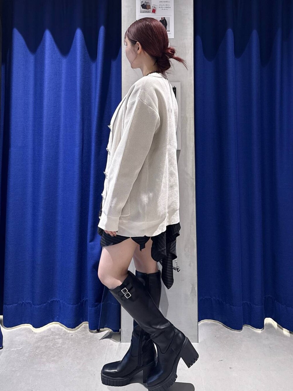 ホワイト系のタンクトップ、ブラック系のブーツ、ブラック系のハンドバッグを着用したレディースの秋コーディネートの3枚目の写真