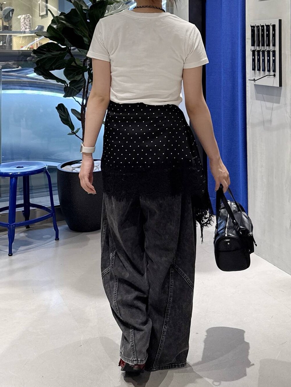 ブラック系のショルダーバッグ、ホワイト系のTシャツ/カットソー、ブラック系のデニムパンツを着用したレディースの夏コーディネートの4枚目の写真