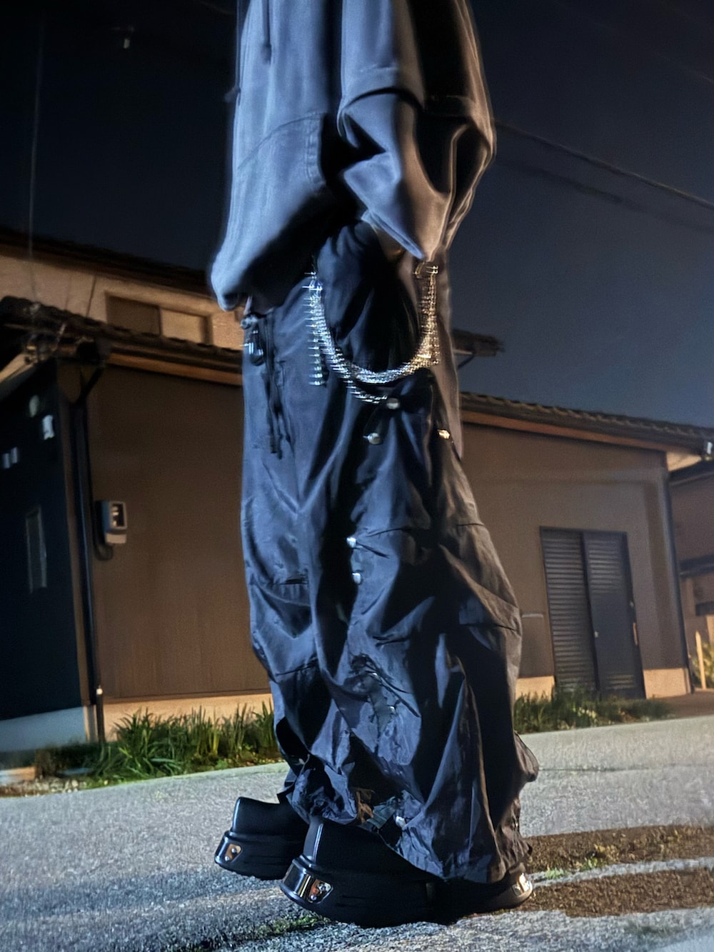 ブラック系のパーカー、グレー系のその他パンツ、ブラック系のドレスシューズを着用したメンズの春コーディネートの2枚目の写真