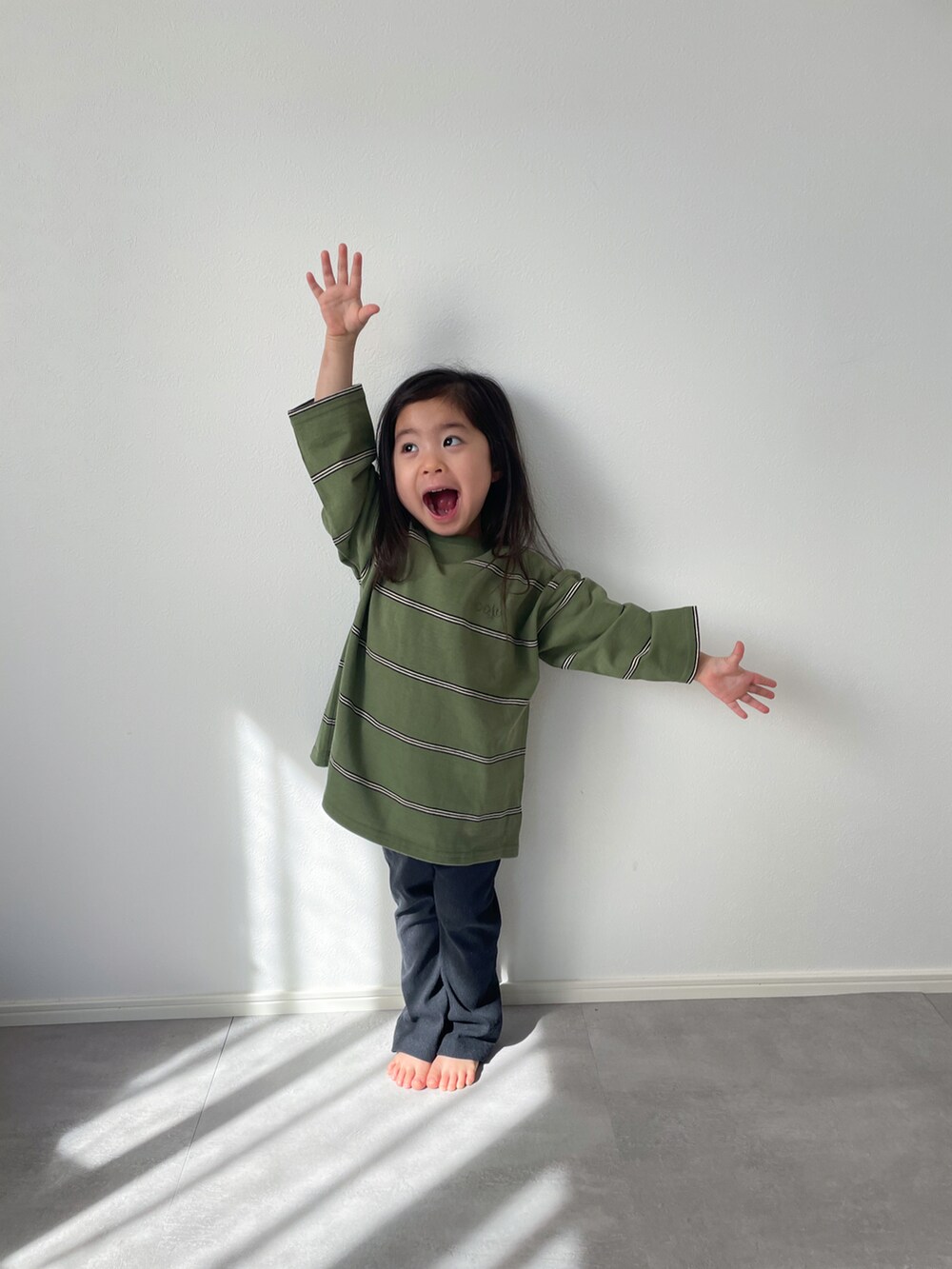 グレー系のその他パンツ、グリーン系のTシャツ/カットソーを着用したキッズの春コーディネートの2枚目の写真