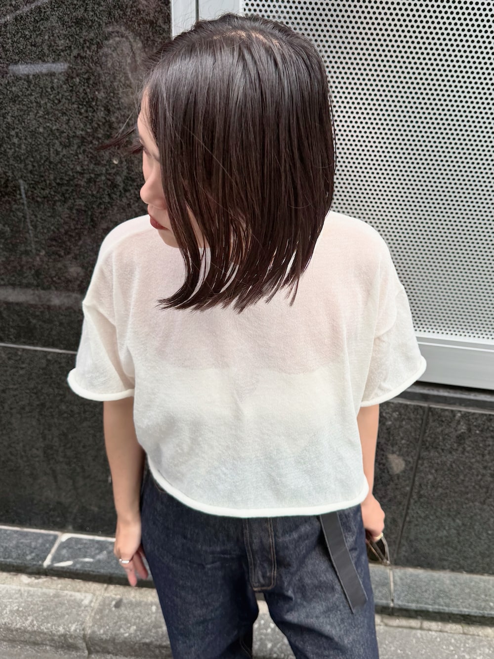 ブルー系のデニムパンツ、ホワイト系のニット/セーターを着用したレディースの夏コーディネートの2枚目の写真