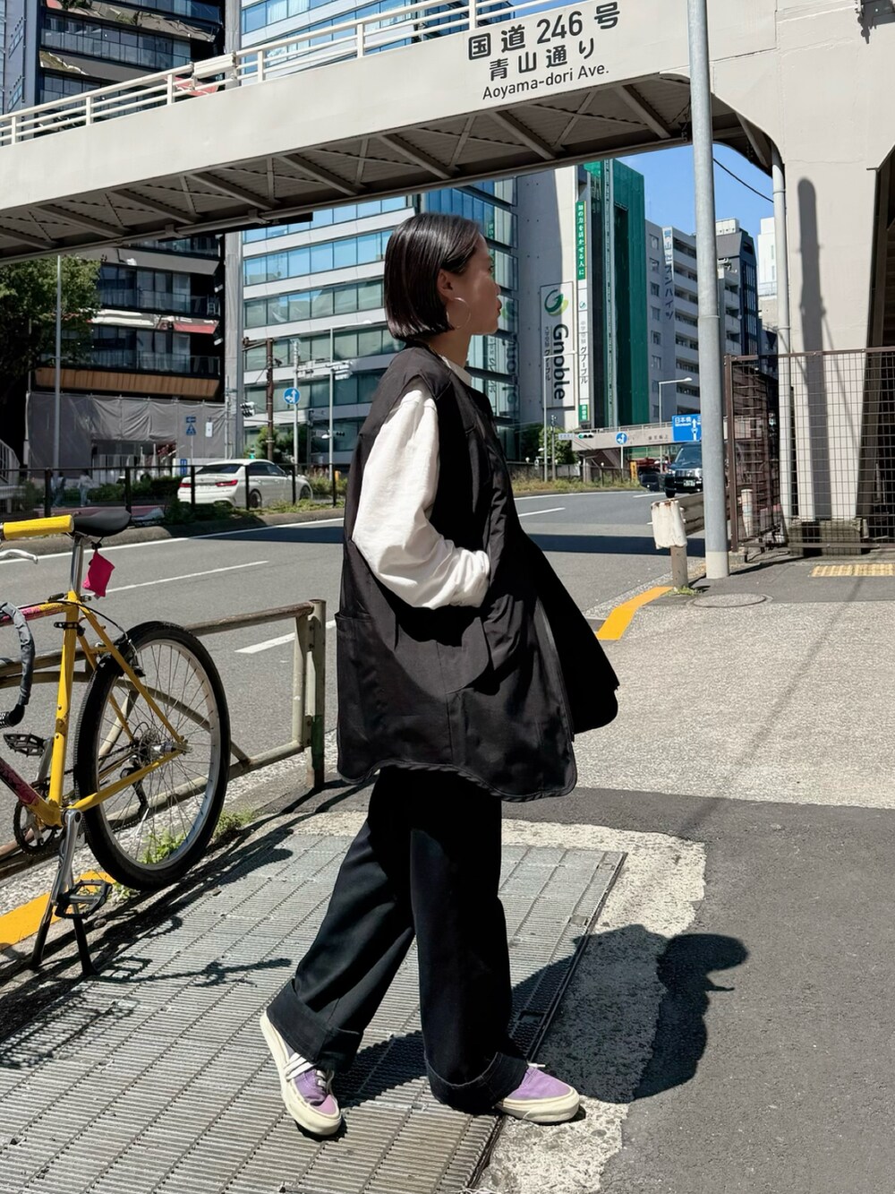 ブラック系のベストを着用したレディースの春コーディネートの2枚目の写真