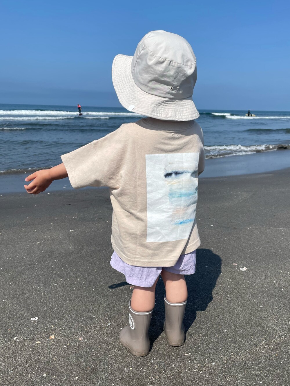 グレー系のTシャツ/カットソー、パープル系の水着、ベージュ系のハットを着用したレディースの春コーディネートの2枚目の写真