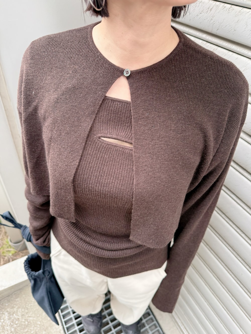 ブラウン系のカーディガン/ボレロ、ブラック系のハンドバッグを着用したレディースの冬コーディネートの2枚目の写真