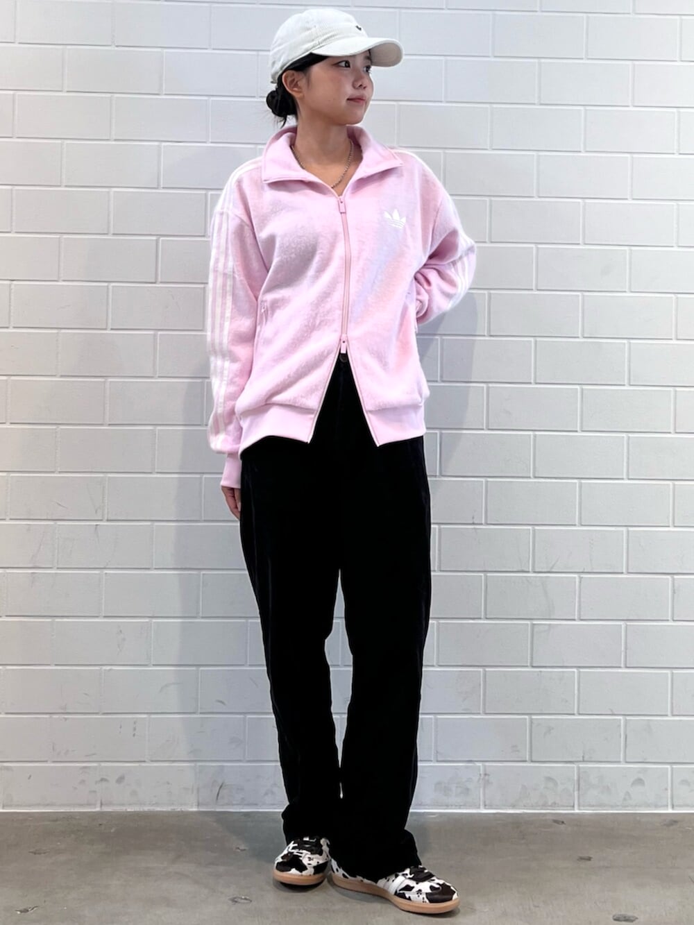 ブラウン系のスニーカー、ピンク系のジャージ、ホワイト系のキャップを着用したレディースの秋コーディネートの3枚目の写真