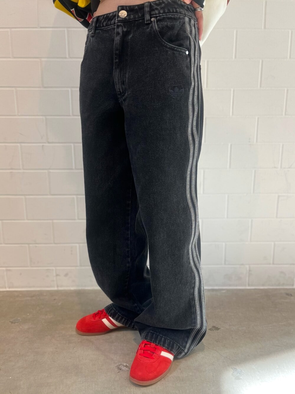 ブラック系のデニムパンツ、イエロー系のスウェット、レッド系のスニーカーを着用したレディースの秋コーディネートの5枚目の写真