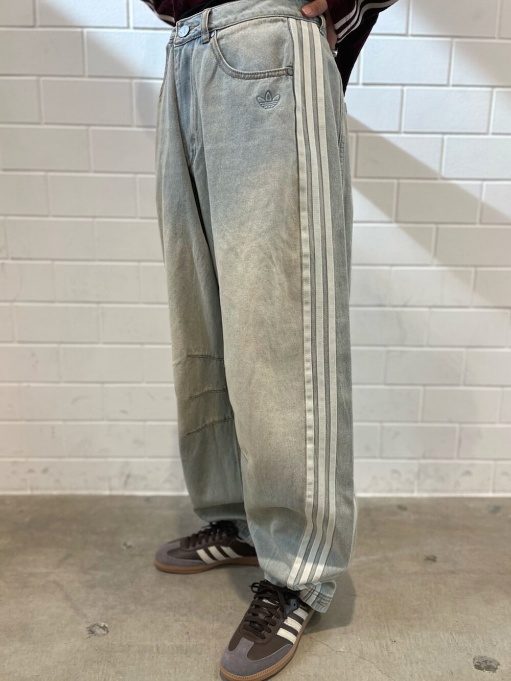 ブラウン系のスニーカー、ブルー系のデニムパンツ、レッド系のTシャツ/カットソーを着用したレディースの秋コーディネートの5枚目の写真