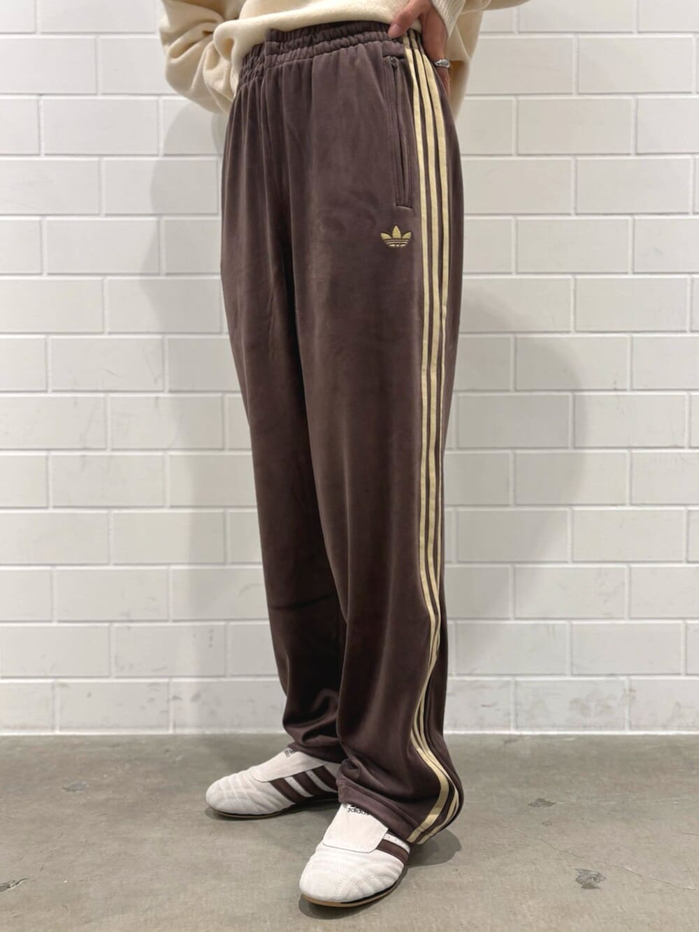 ブラウン系のパンツ、ホワイト系のニット/セーター、ベージュ系のショルダーバッグを着用したレディースの秋コーディネートの4枚目の写真