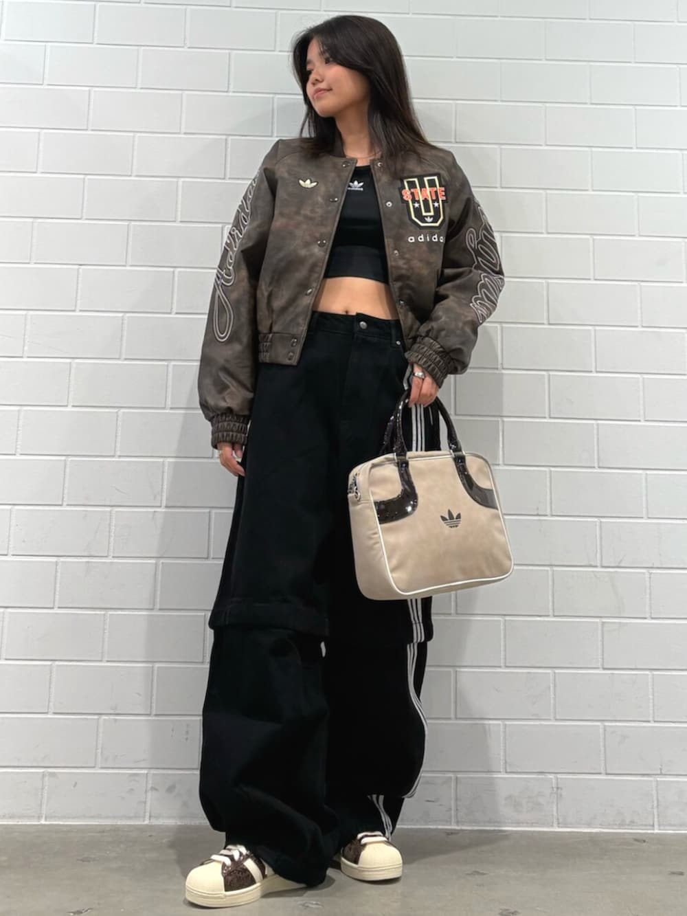 ベージュ系のショルダーバッグ、ブラウン系のジャケット/アウター、ブラック系のTシャツ/カットソーを着用したレディースの秋コーディネートの3枚目の写真