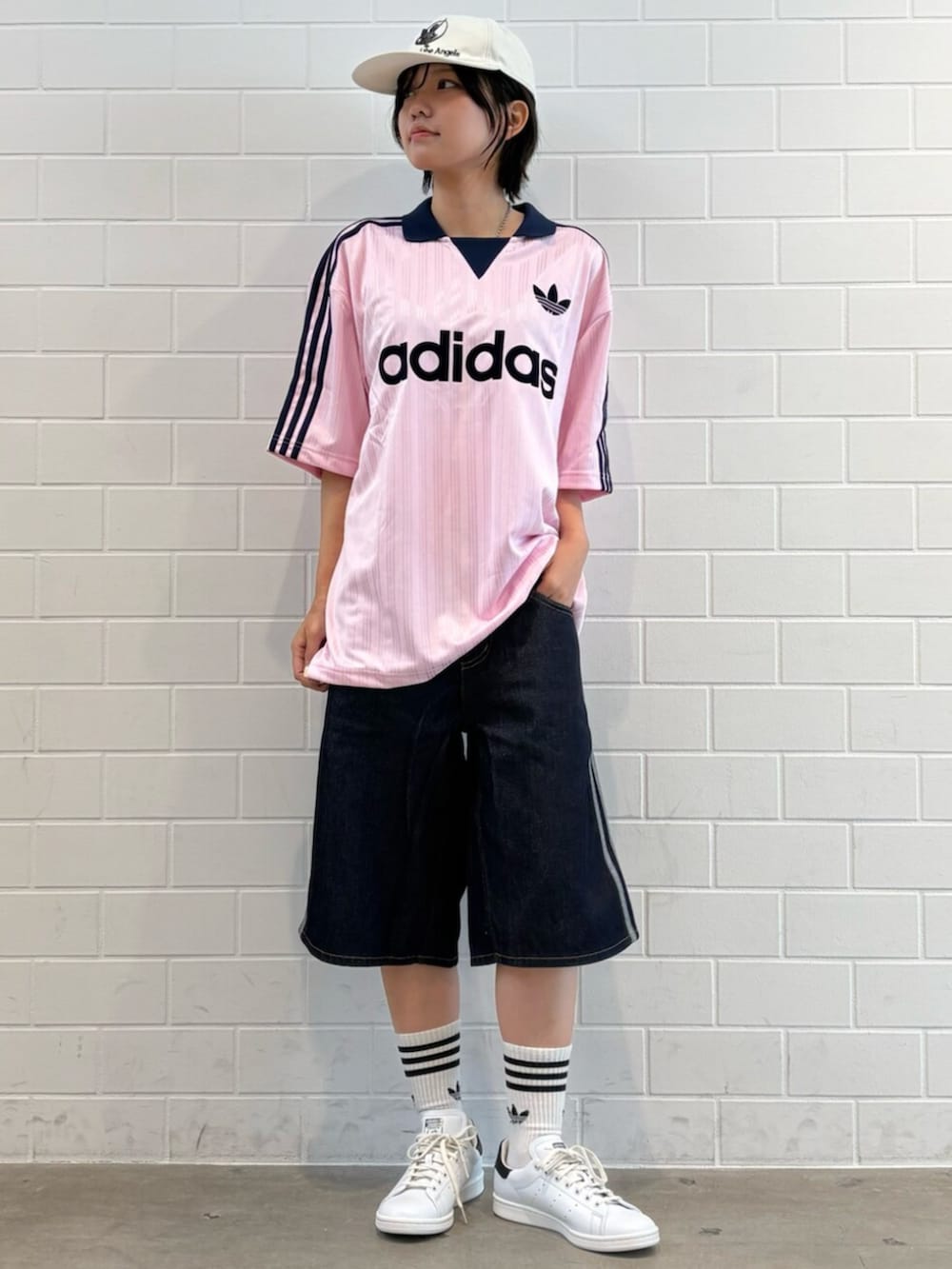 ブルー系のデニムパンツ、ピンク系のTシャツ/カットソー、ホワイト系のスニーカーを着用したレディースの夏コーディネートの3枚目の写真