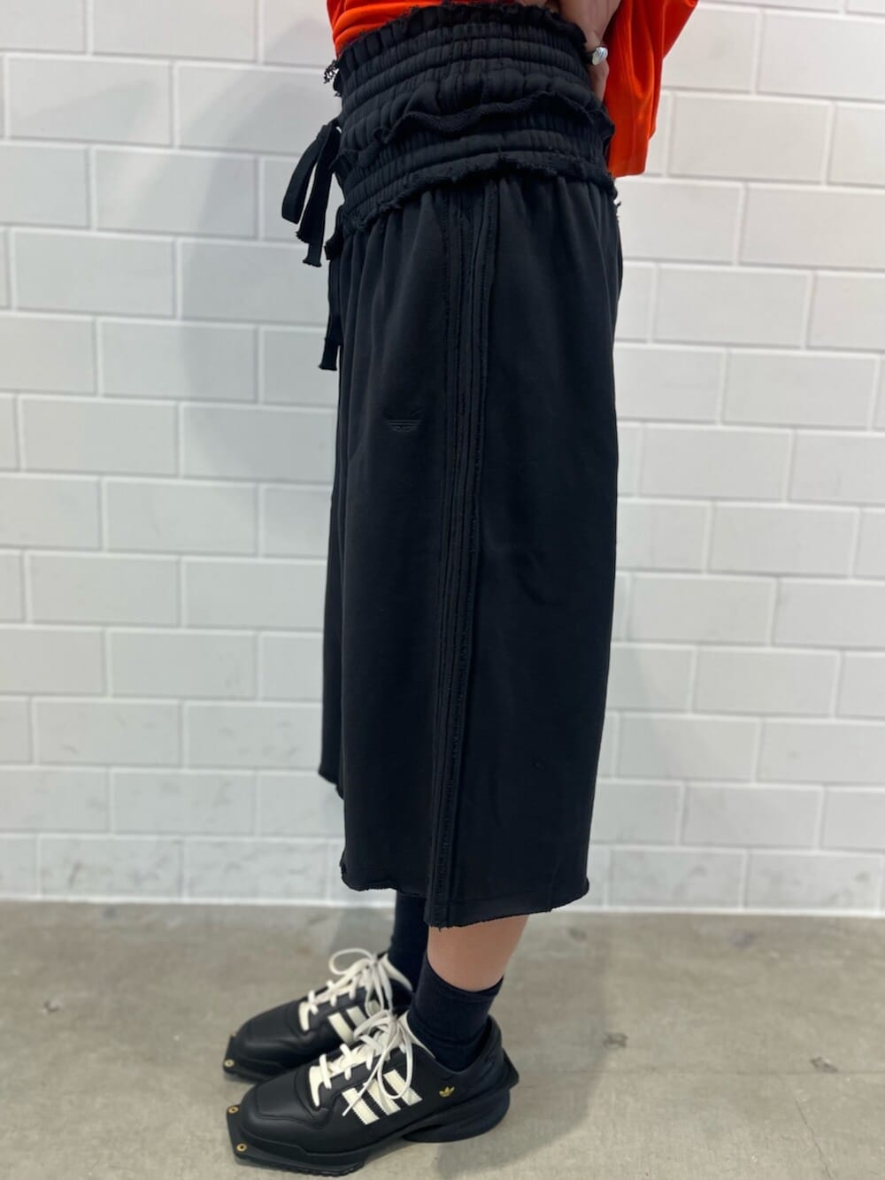ブラック系のシューズ、オレンジ系のTシャツ/カットソー、ブラック系のその他パンツを着用したレディースの秋コーディネートの5枚目の写真