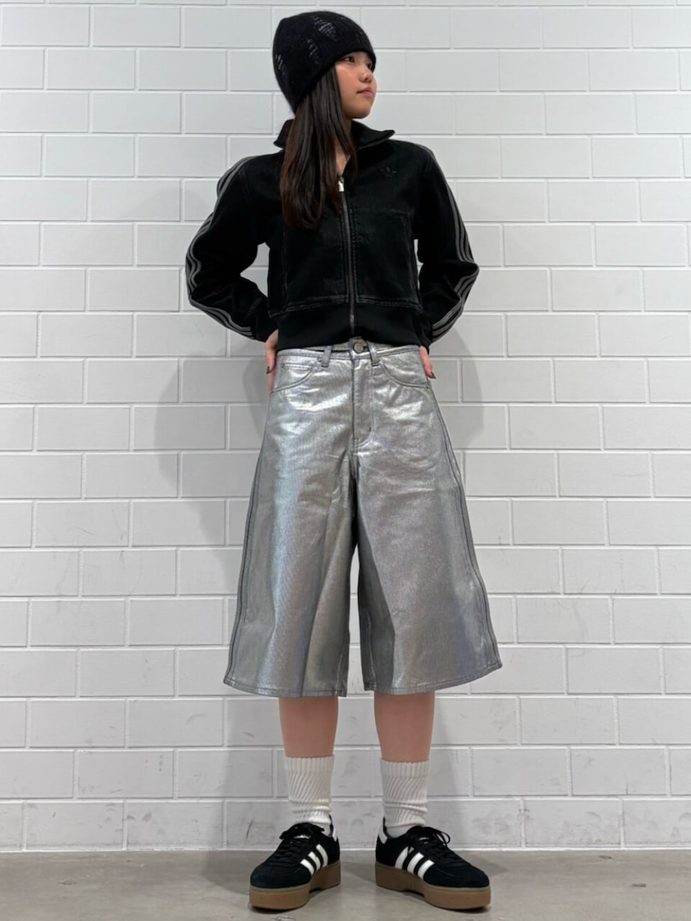 ブラック系のデニムジャケット、ブラック系のスニーカー、シルバー系のデニムパンツを着用したレディースの冬コーディネートの3枚目の写真