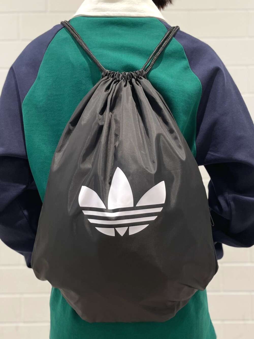 ブラック系のエコバッグ/サブバッグ、ブラック系のその他パンツ、グリーン系のポロシャツを着用したレディースの冬コーディネートの4枚目の写真