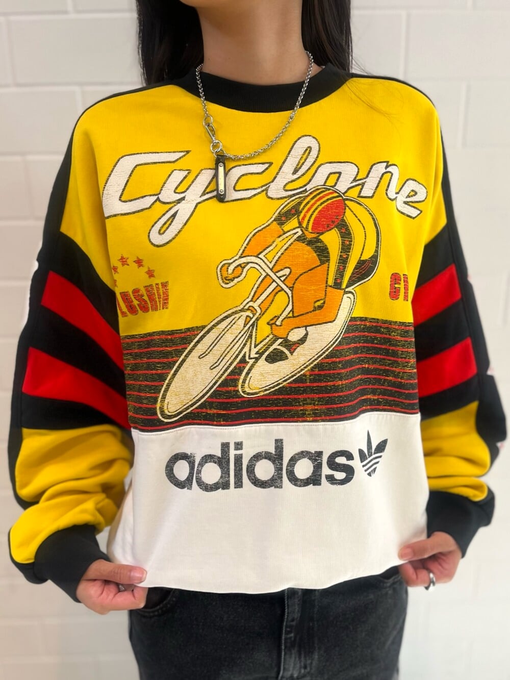 ブラック系のデニムパンツ、イエロー系のスウェット、レッド系のスニーカーを着用したレディースの秋コーディネートの3枚目の写真