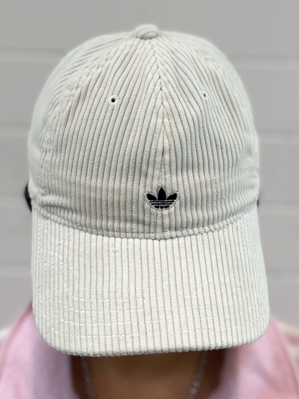 ブラウン系のスニーカー、ピンク系のジャージ、ホワイト系のキャップを着用したレディースの秋コーディネートの4枚目の写真