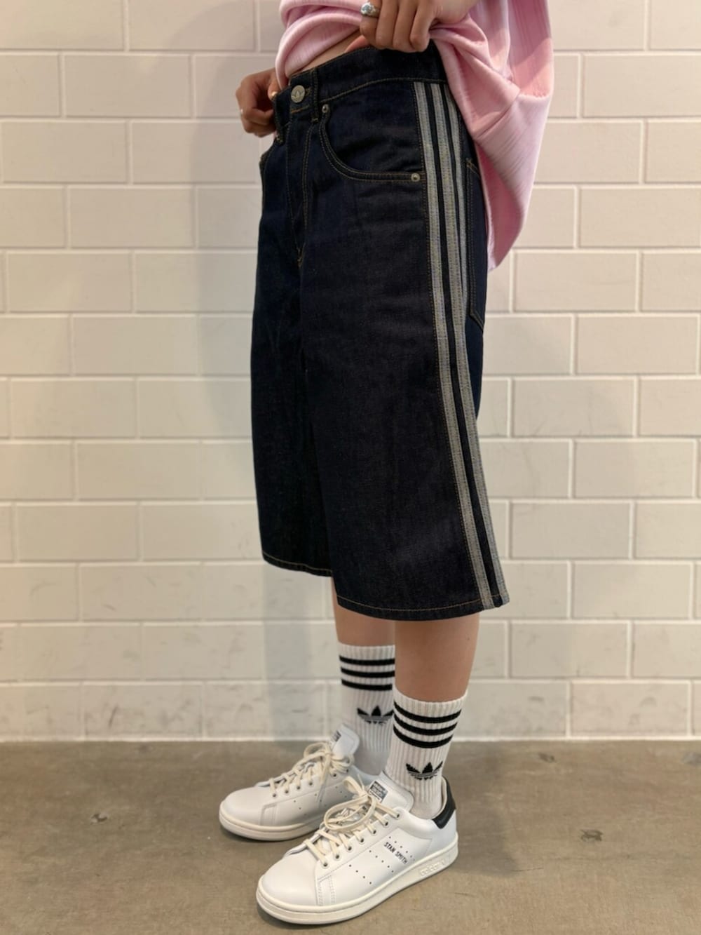 ブルー系のデニムパンツ、ピンク系のTシャツ/カットソー、ホワイト系のスニーカーを着用したレディースの夏コーディネートの5枚目の写真