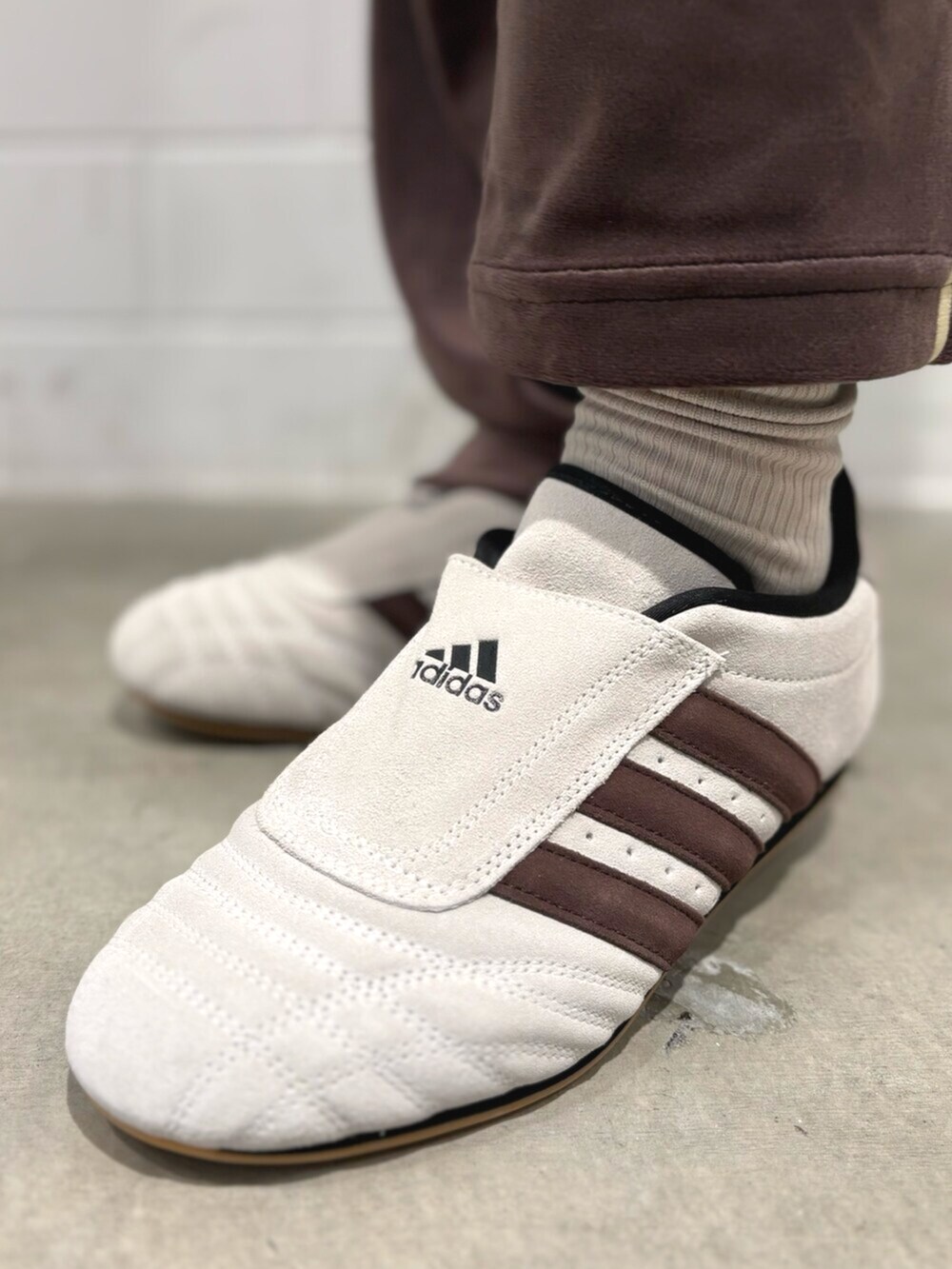 ブラウン系のパンツ、ホワイト系のニット/セーター、ベージュ系のショルダーバッグを着用したレディースの秋コーディネートの6枚目の写真