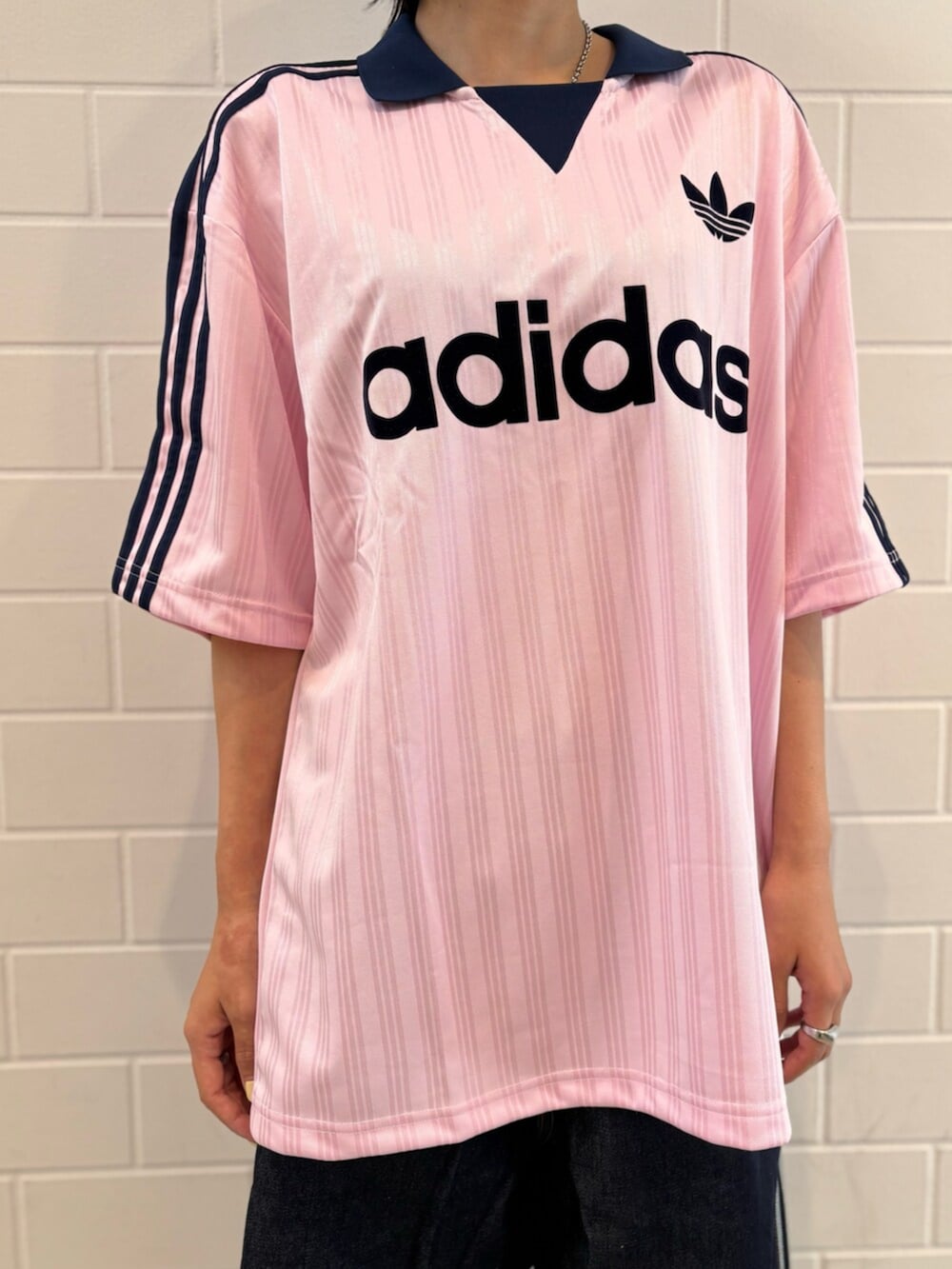 ブルー系のデニムパンツ、ピンク系のTシャツ/カットソー、ホワイト系のスニーカーを着用したレディースの夏コーディネートの4枚目の写真