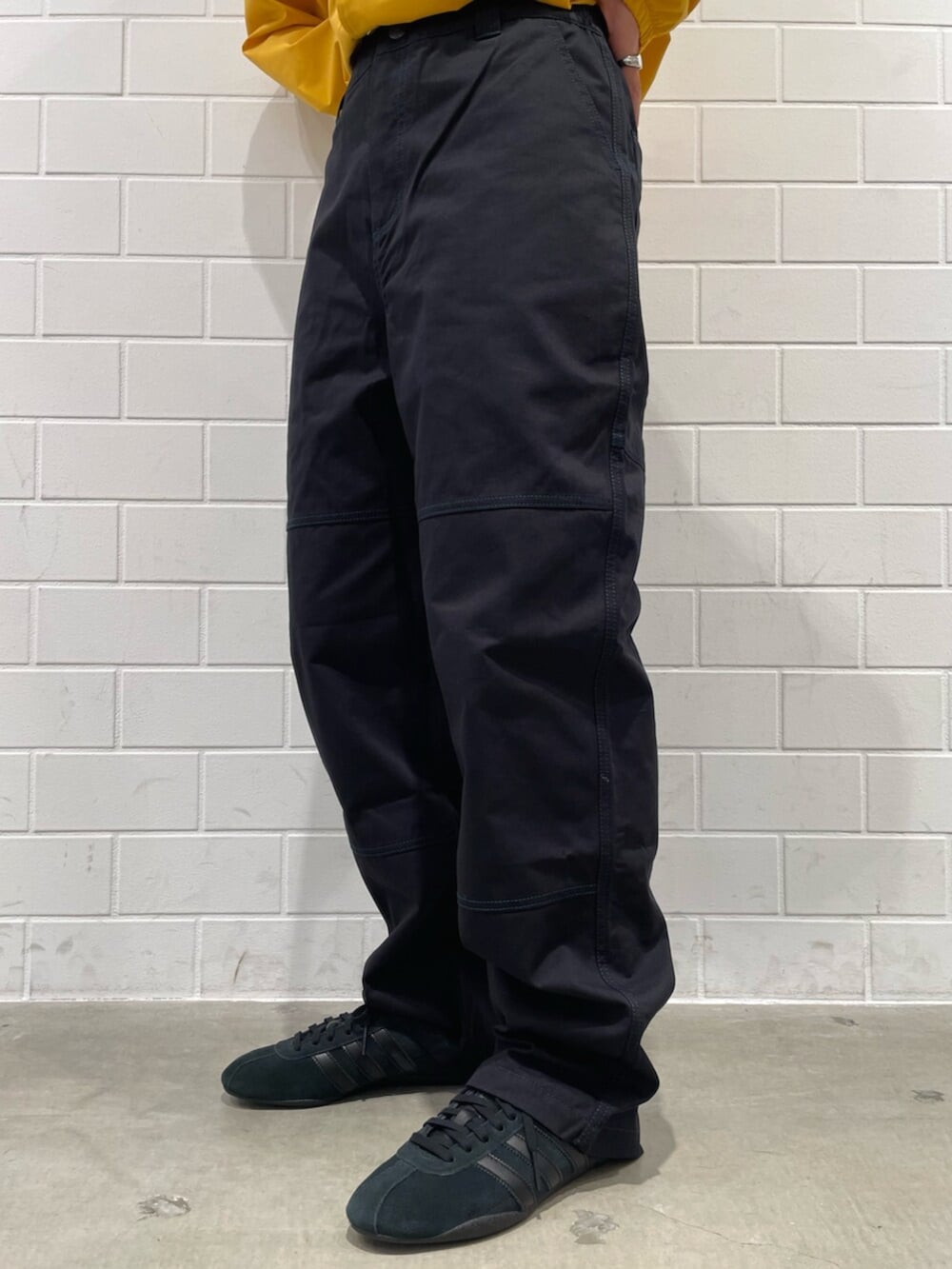 イエロー系のブルゾン、ブラック系のその他パンツ、ブラック系のスニーカーを着用したレディースの冬コーディネートの5枚目の写真