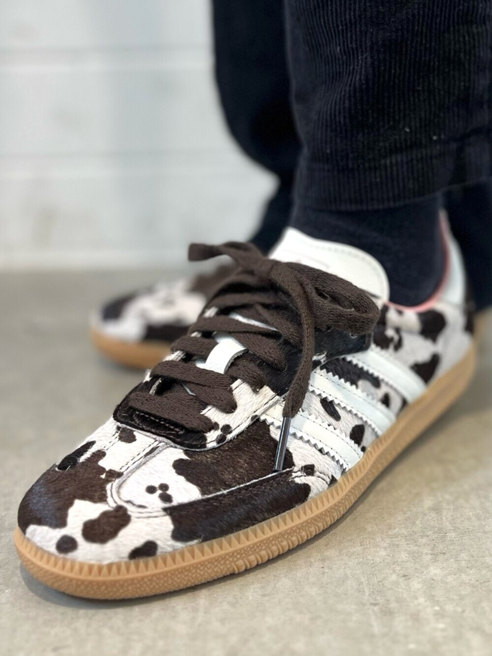 ブラウン系のスニーカー、ピンク系のジャージ、ホワイト系のキャップを着用したレディースの秋コーディネートの6枚目の写真