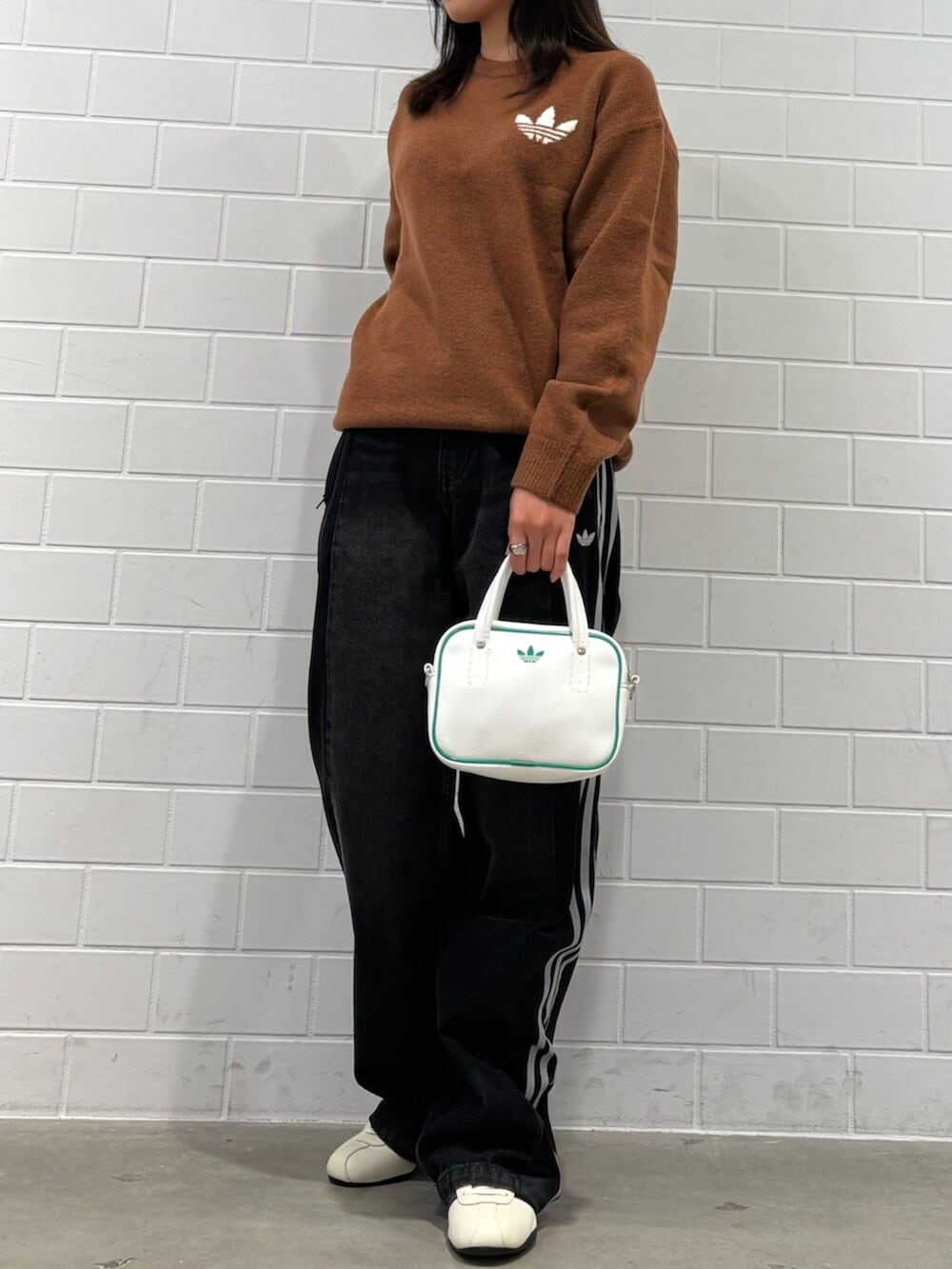 ホワイト系のスニーカー、ブラック系のその他パンツ、ホワイト系のショルダーバッグを着用したレディースの秋コーディネートの2枚目の写真