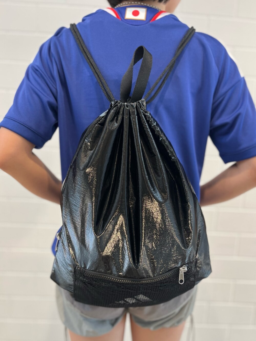 グレー系のスニーカー、ブラック系のエコバッグ/サブバッグ、ブルー系のTシャツ/カットソーを着用したレディースの夏コーディネートの5枚目の写真