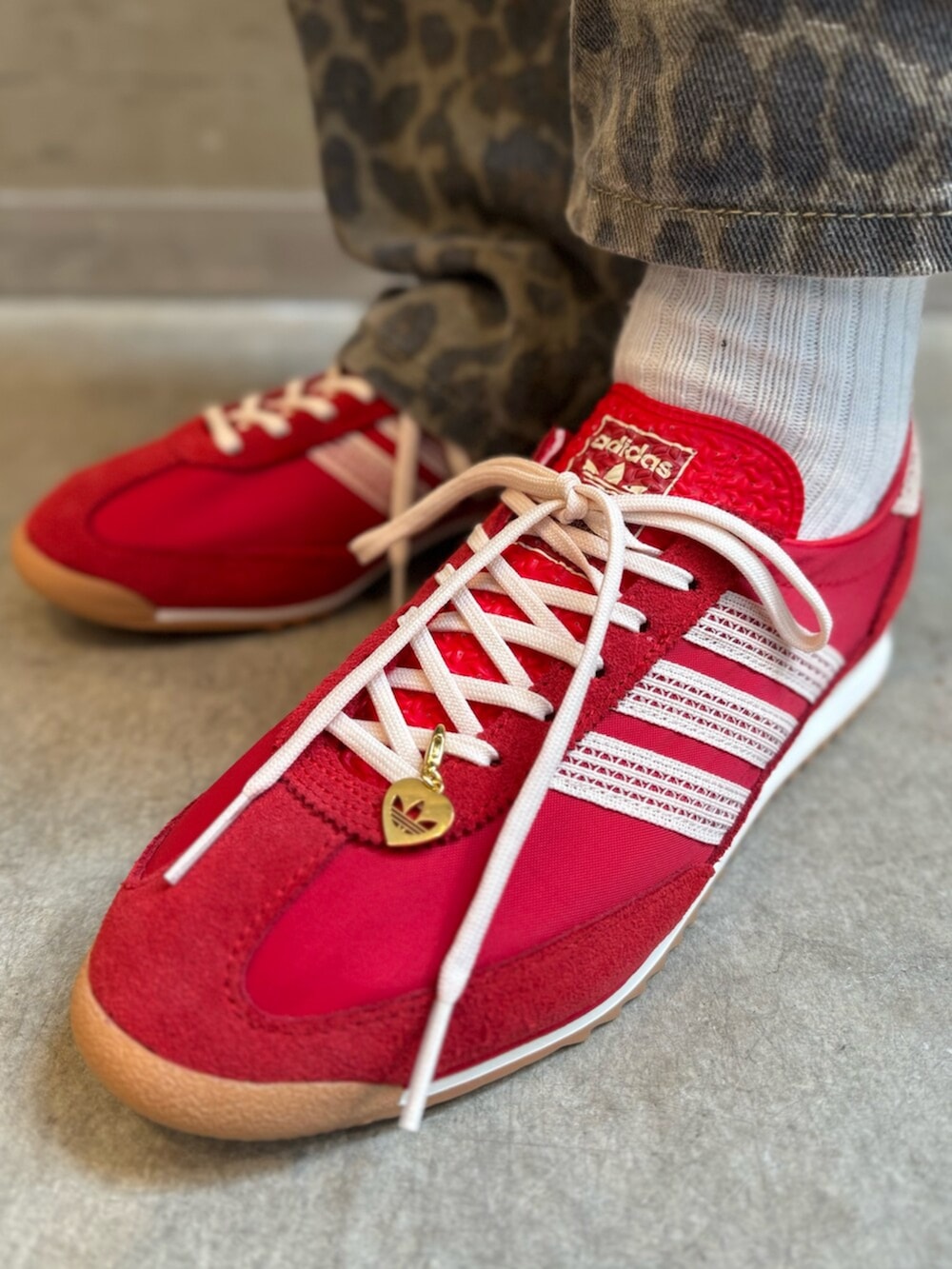 ブラック系のシューズアクセサリー、ブラック系のTシャツ/カットソー、レッド系のスニーカーを着用したレディースの夏コーディネートの6枚目の写真