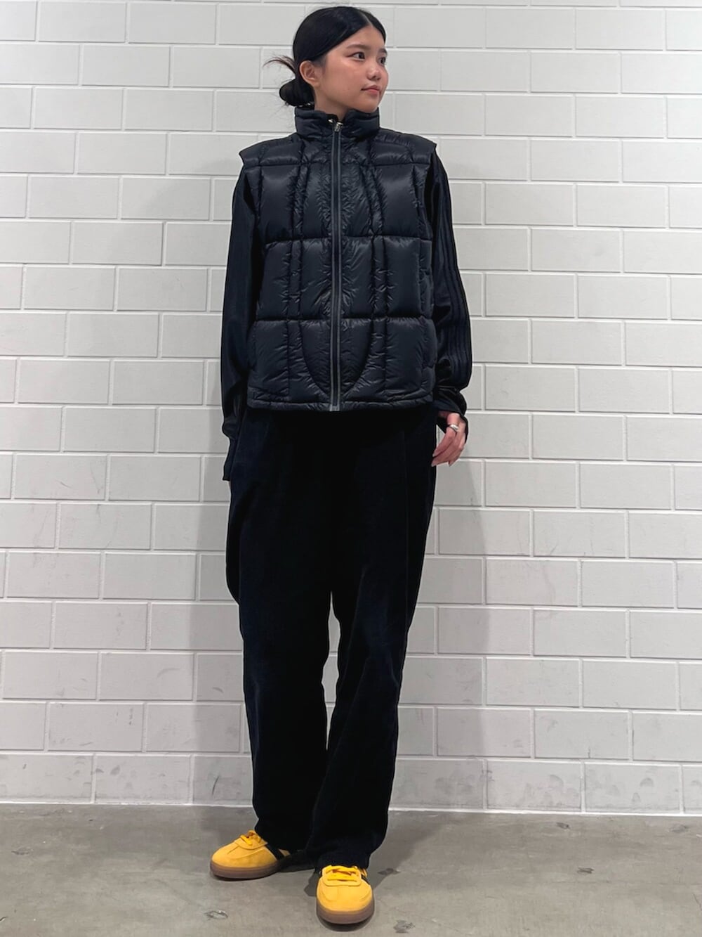 ブラック系のジャケット/アウター、イエロー系のスニーカー、ブラック系のジャージを着用したレディースの冬コーディネートの3枚目の写真