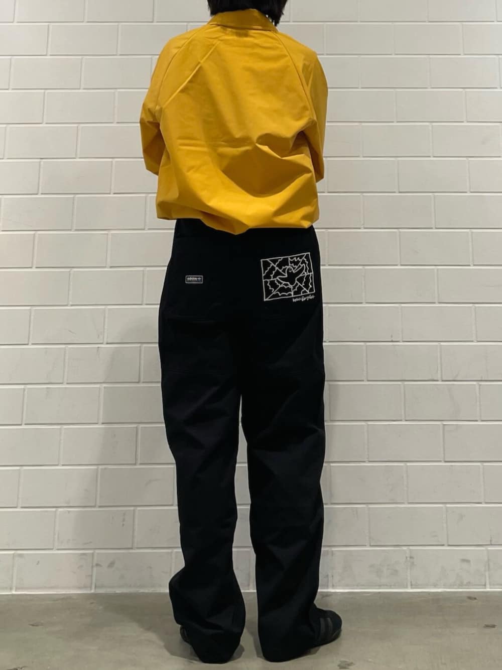 イエロー系のブルゾン、ブラック系のその他パンツ、ブラック系のスニーカーを着用したレディースの冬コーディネートの2枚目の写真