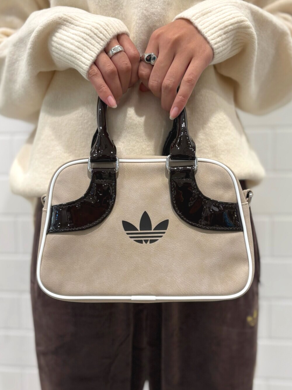 ブラウン系のパンツ、ホワイト系のニット/セーター、ベージュ系のショルダーバッグを着用したレディースの秋コーディネートの5枚目の写真